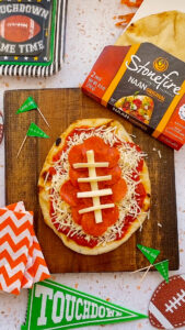 A video of a football-shaped pizza recipe featuring Stonefire® original naan.